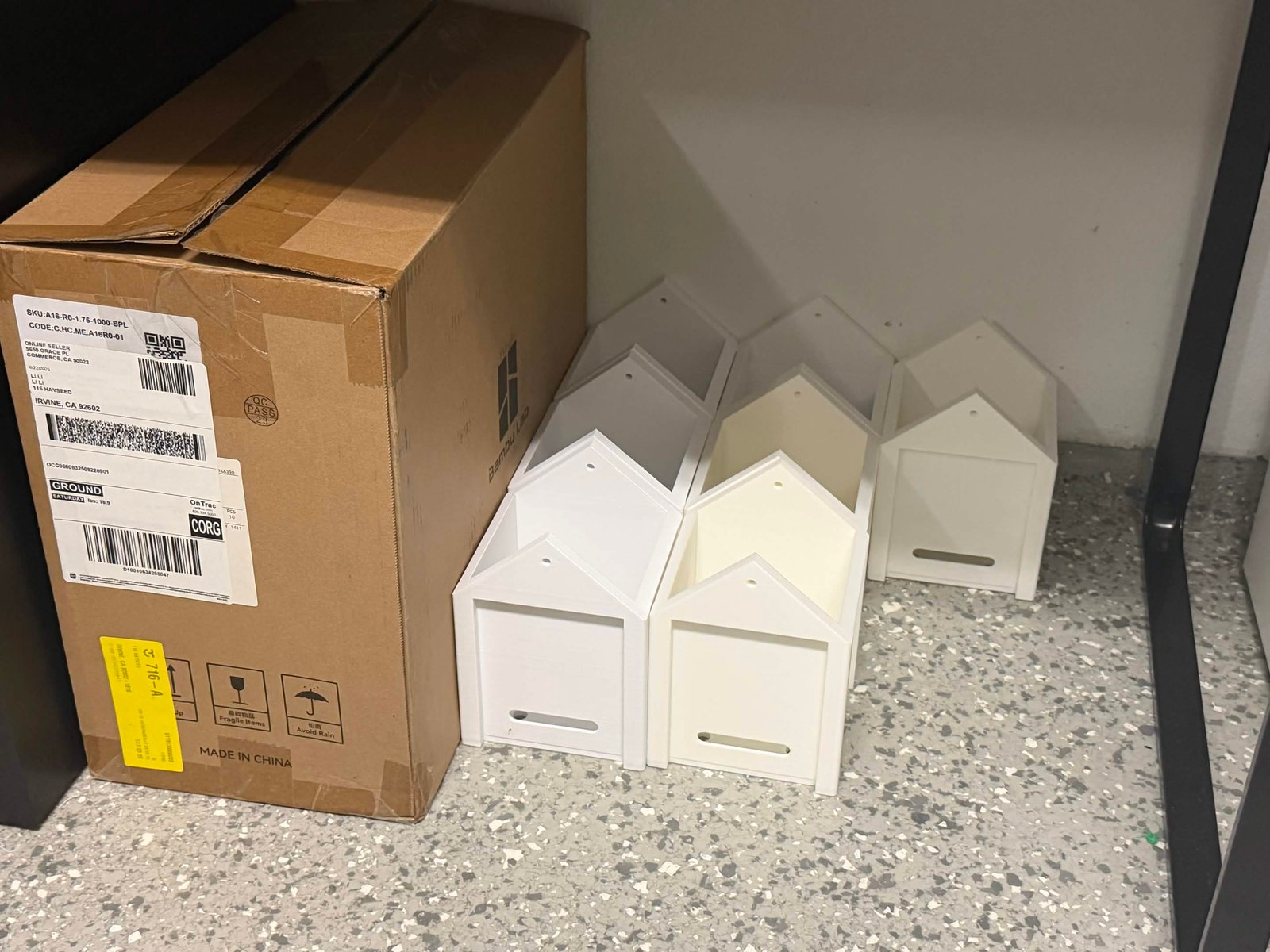 A 3d printed nest box sitting on top of a garden shrub